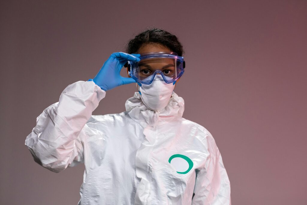 Woman wearing full protective gear with mask and goggles, ensuring safety.